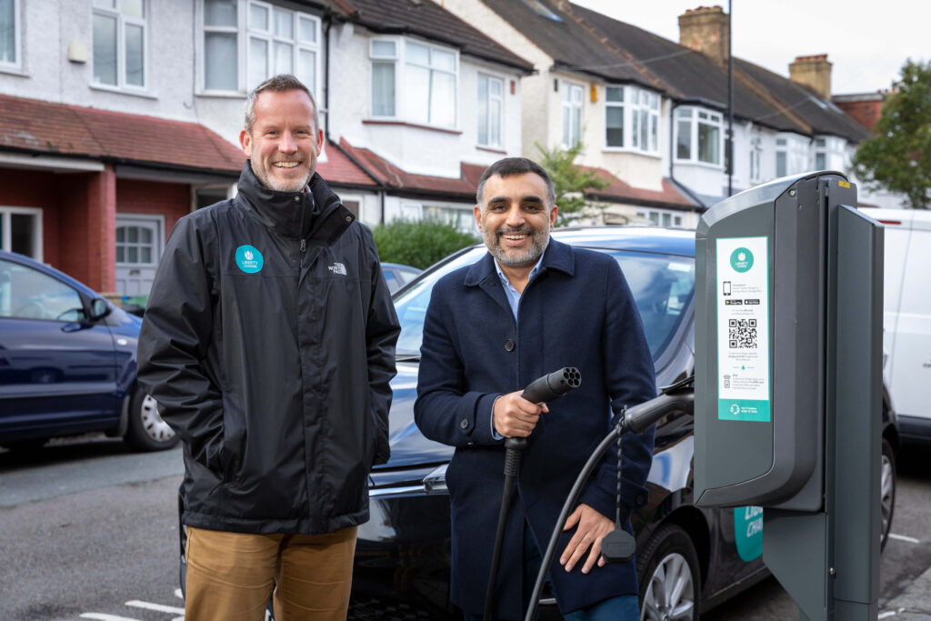 Two men standing next to charge point