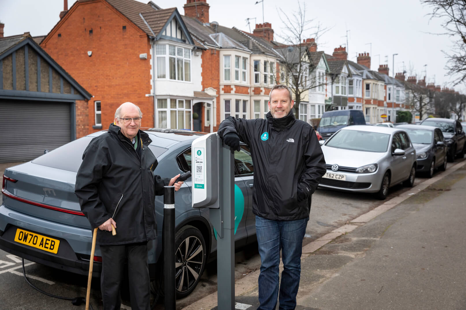 Senior man charging a car with charge point