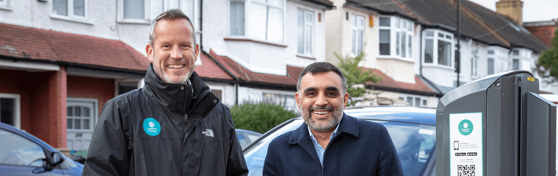 Two men standing next to charge point