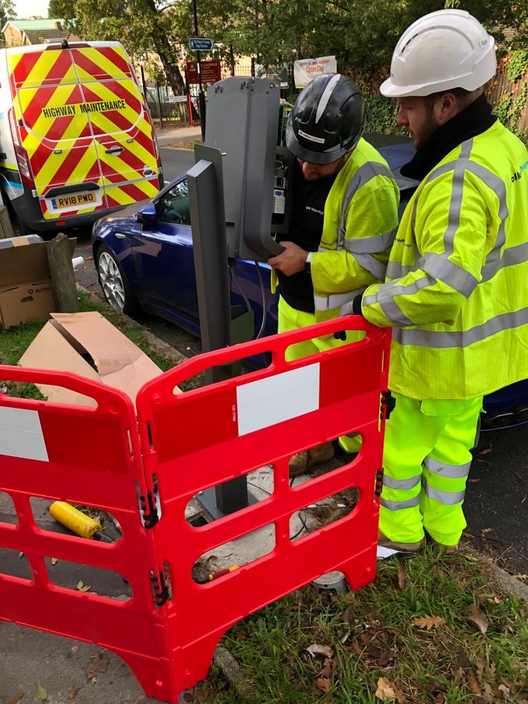 Two men installing a car charging point