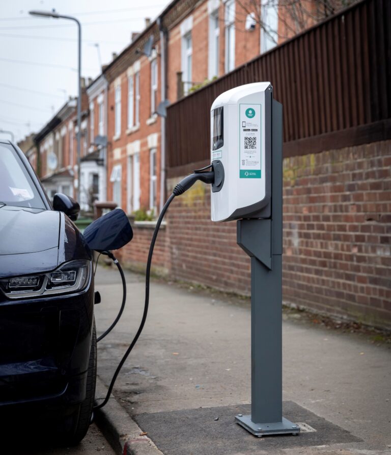 Car under charging and a string of residential houses