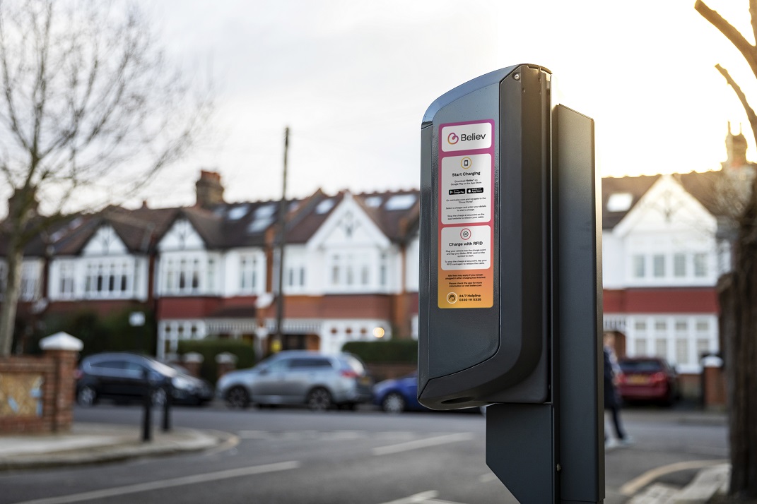 Road, car charger, residential buildings in the background